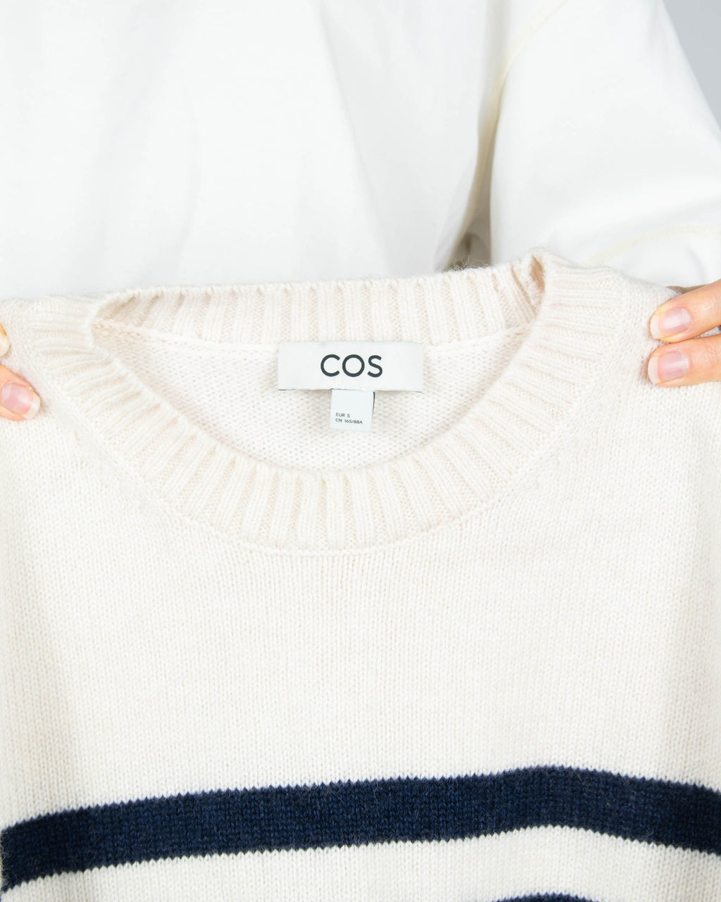 Cream and navy striped wool sweater by COS.