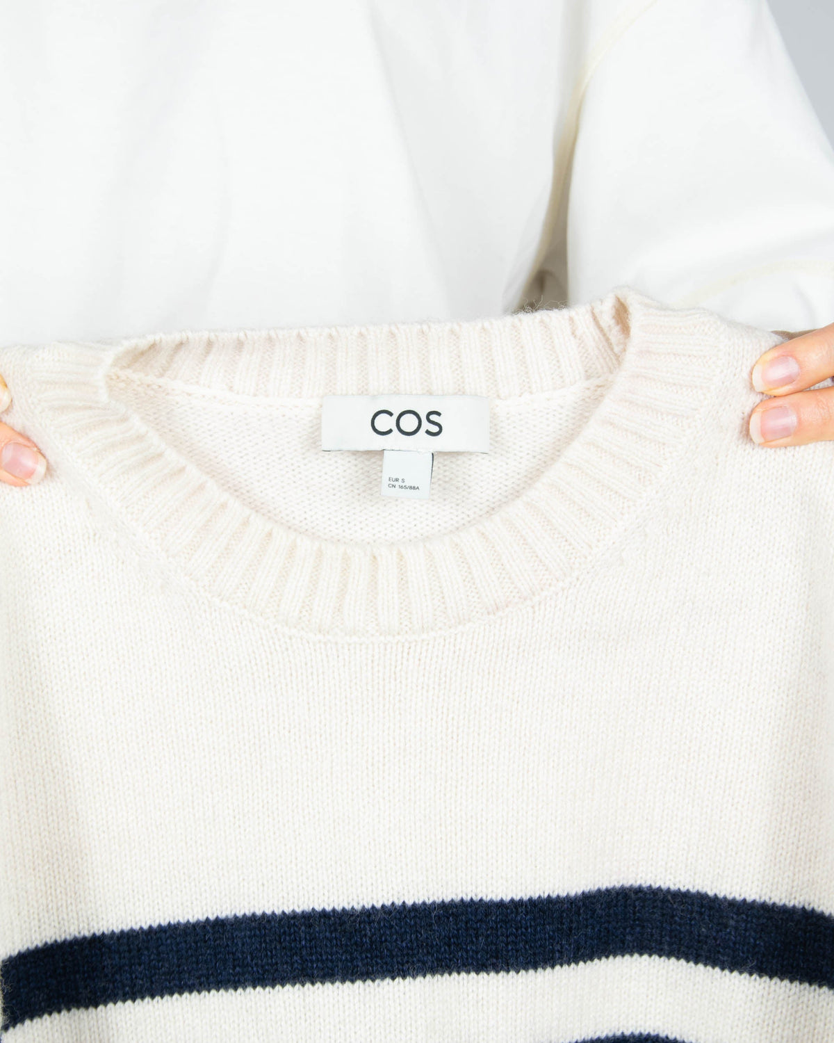 Cream and navy striped wool sweater by COS.