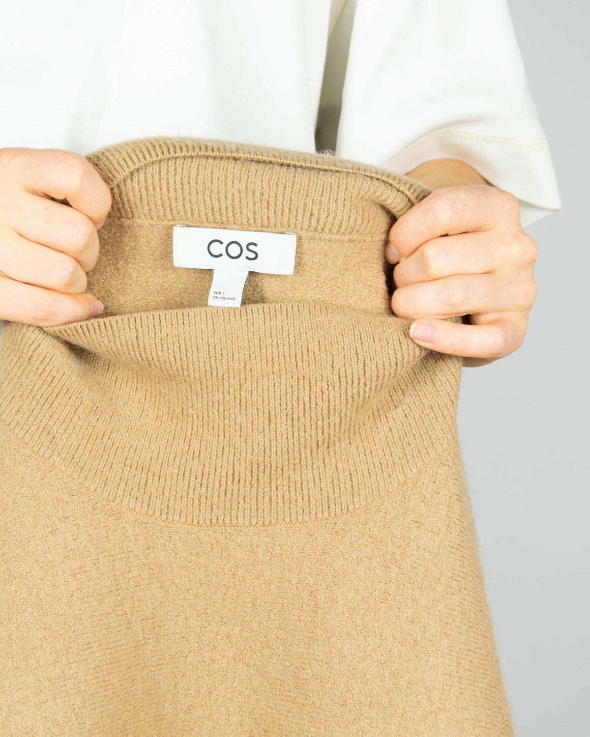Beige boiled merino wool turtleneck sweater by COS.