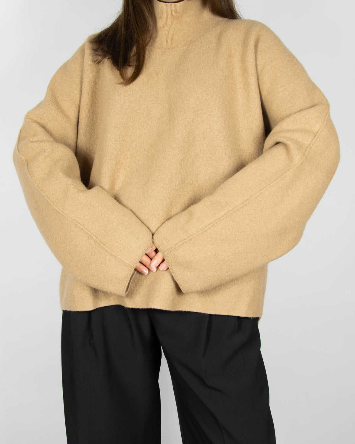 Beige boiled merino wool turtleneck sweater by COS.