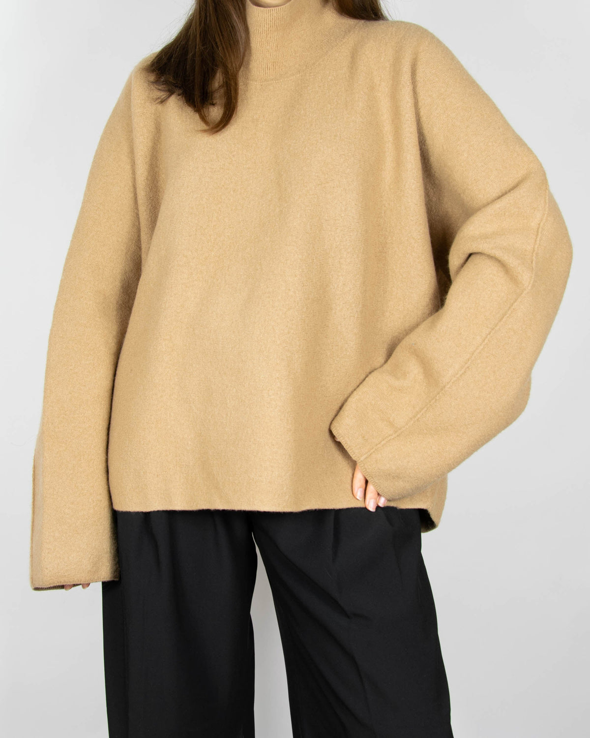 Beige boiled merino wool turtleneck sweater by COS.