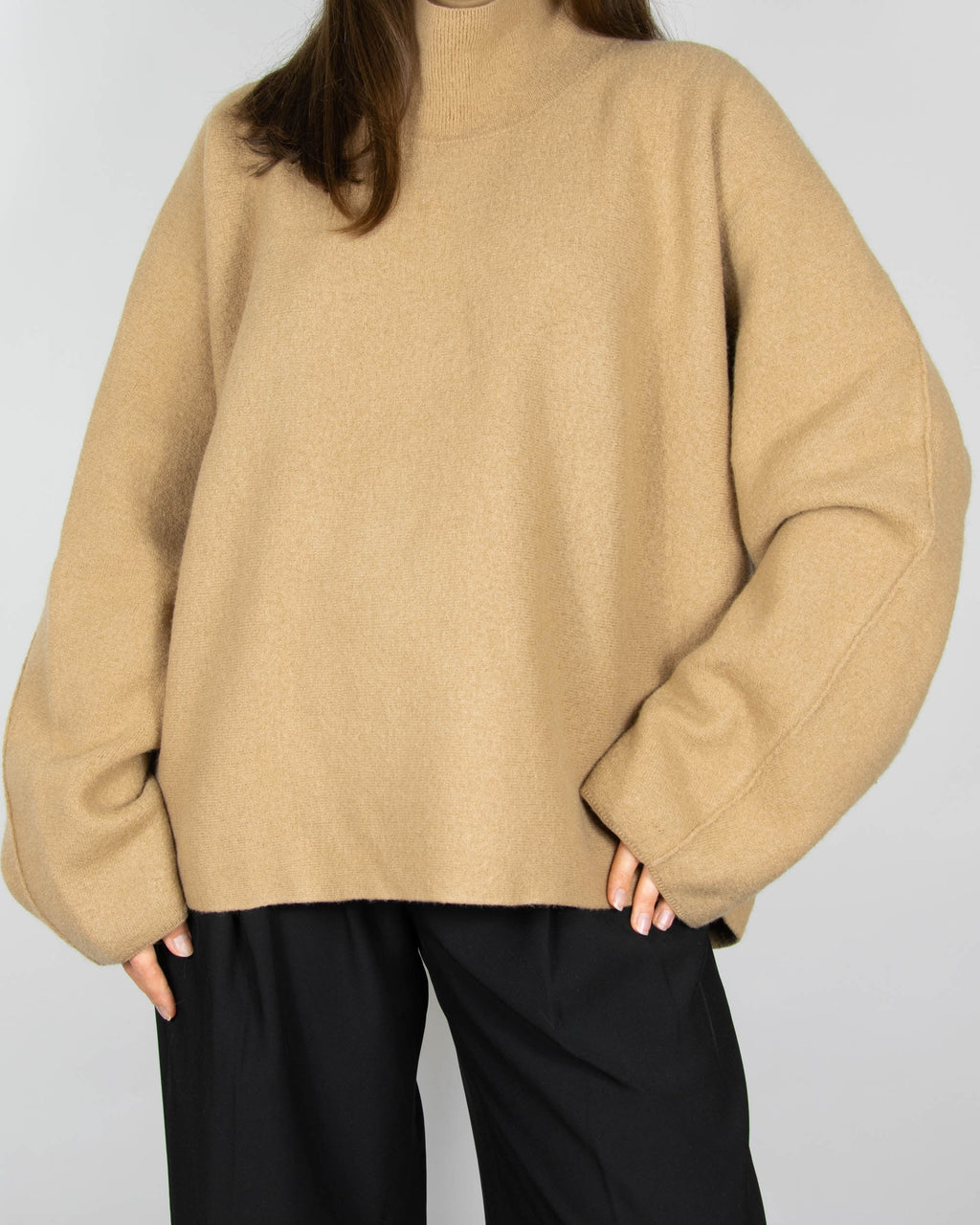 Beige boiled merino wool turtleneck sweater by COS.
