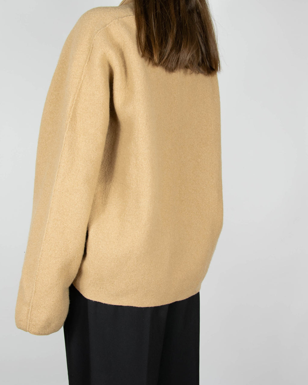 Beige boiled merino wool turtleneck sweater by COS.