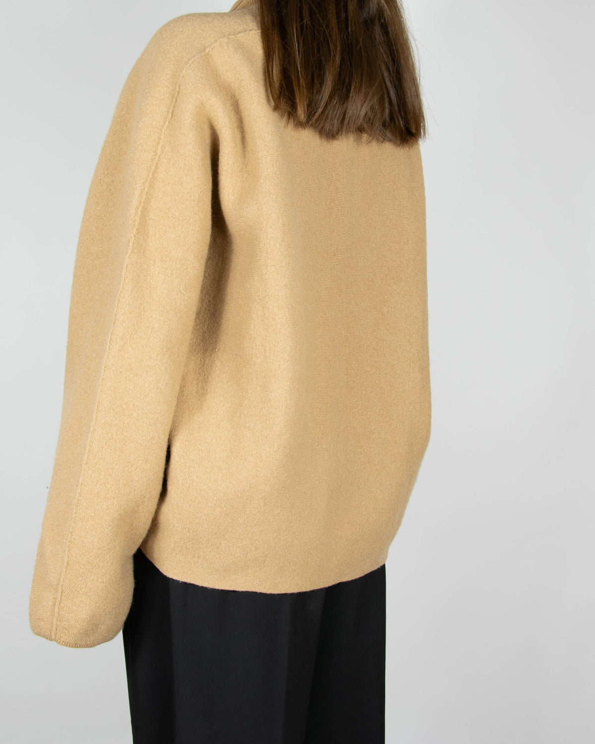 Beige boiled merino wool turtleneck sweater by COS.