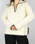 Kremowy bawełniany sweater marki ARKET. Efektownie obszyty grubą czarną nicią